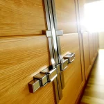 Wooden cabinet doors with modern hinges in bright natural lighting.